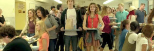 High school characters in Me and Earl and the Dying Girl stand in a crowded lunch room